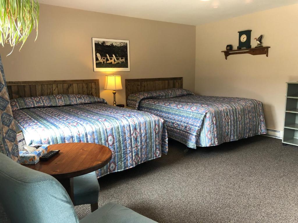a hotel room with two beds and a table at Dwight Village Motel in Dwight