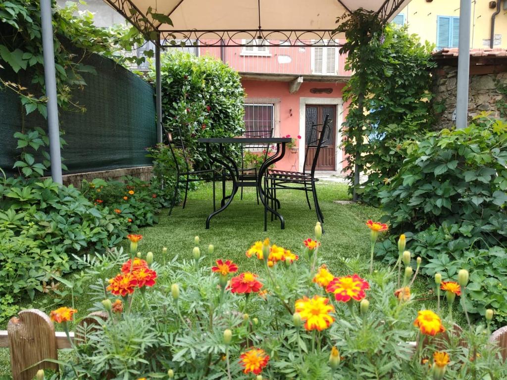 a garden with a table and flowers in the yard at Casa Bartula in Bolzano Novarese