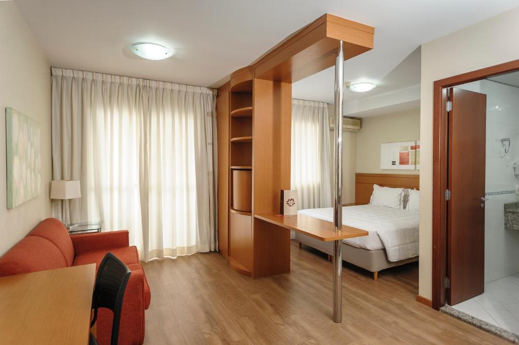 Hotel The Premium في أوساسكو: غرفه فندقيه بسرير واريكه وطاولة