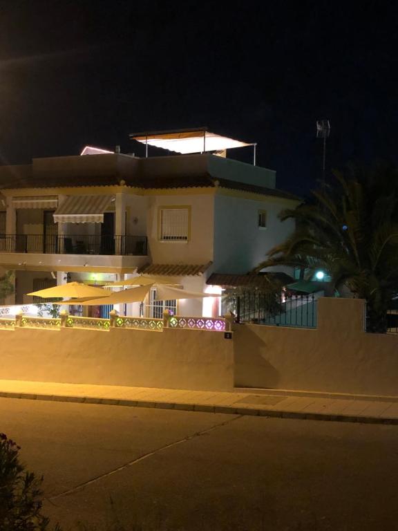 een wit huis met een hek er voor 's nachts bij Saint James Park upstairs in Orihuela-Costa