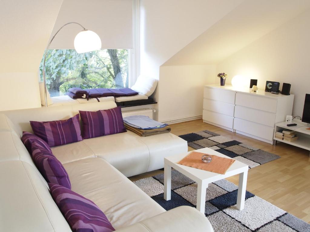 sala de estar con sofá blanco y ventana en Ferienwohnung Bummelallee en Bad Harzburg