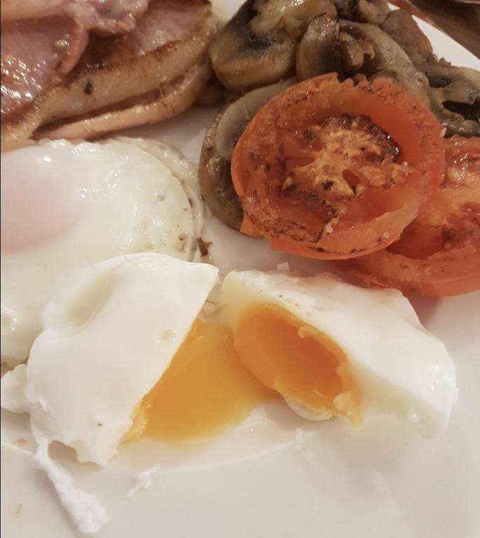 a plate of food with eggs and mushrooms on it at Queenswood Hotel in Weston-super-Mare