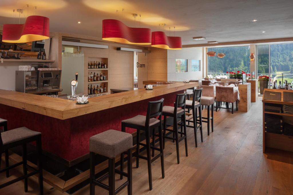 a bar with stools at a restaurant with a counter at Hotel Waldegg - Adults only in Engelberg