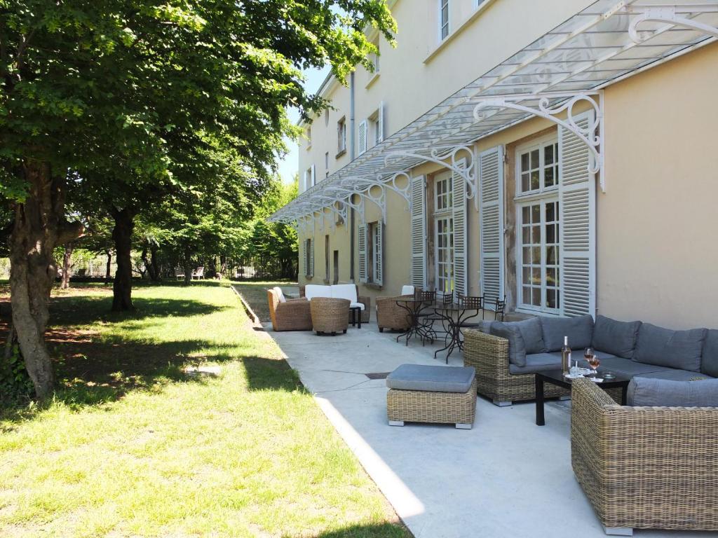 a patio with couches and chairs next to a building at Le Talluy in Taluyers