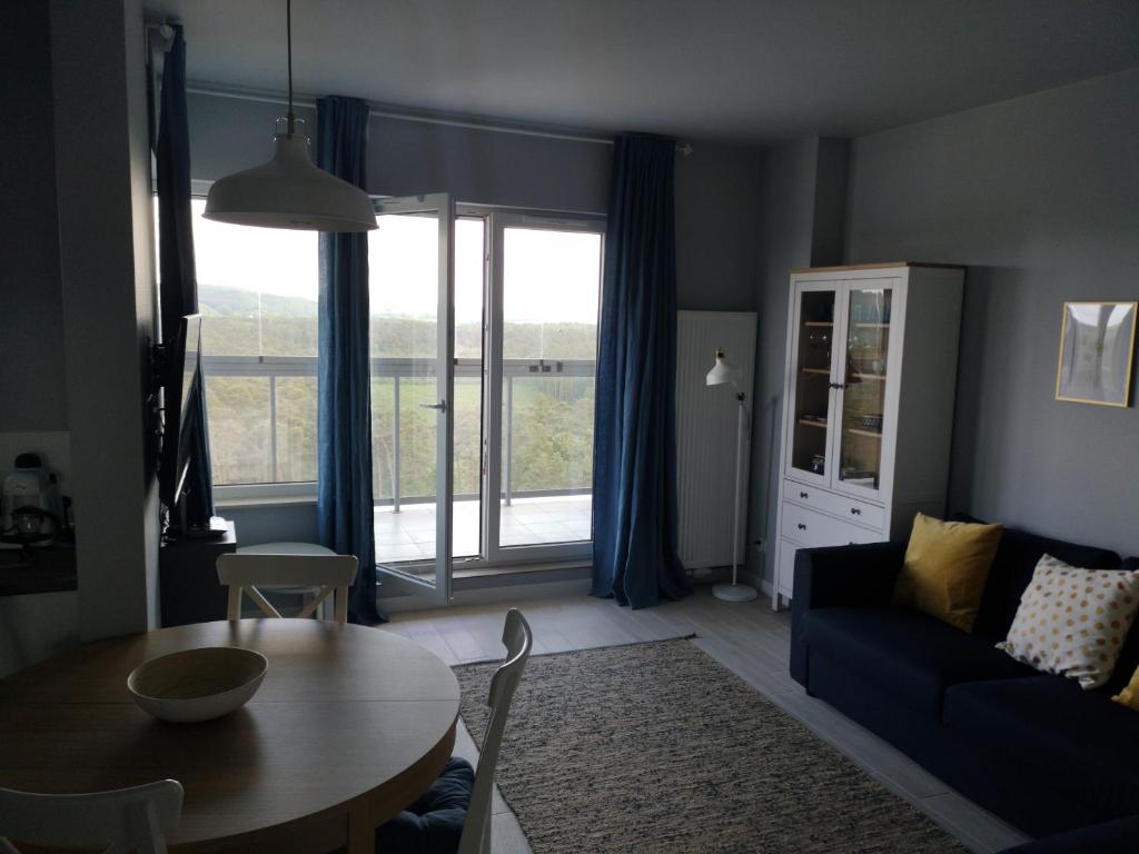 米茲多洛傑的住宿－AQUAMARINA ONYX 147，客厅配有桌子和蓝色沙发