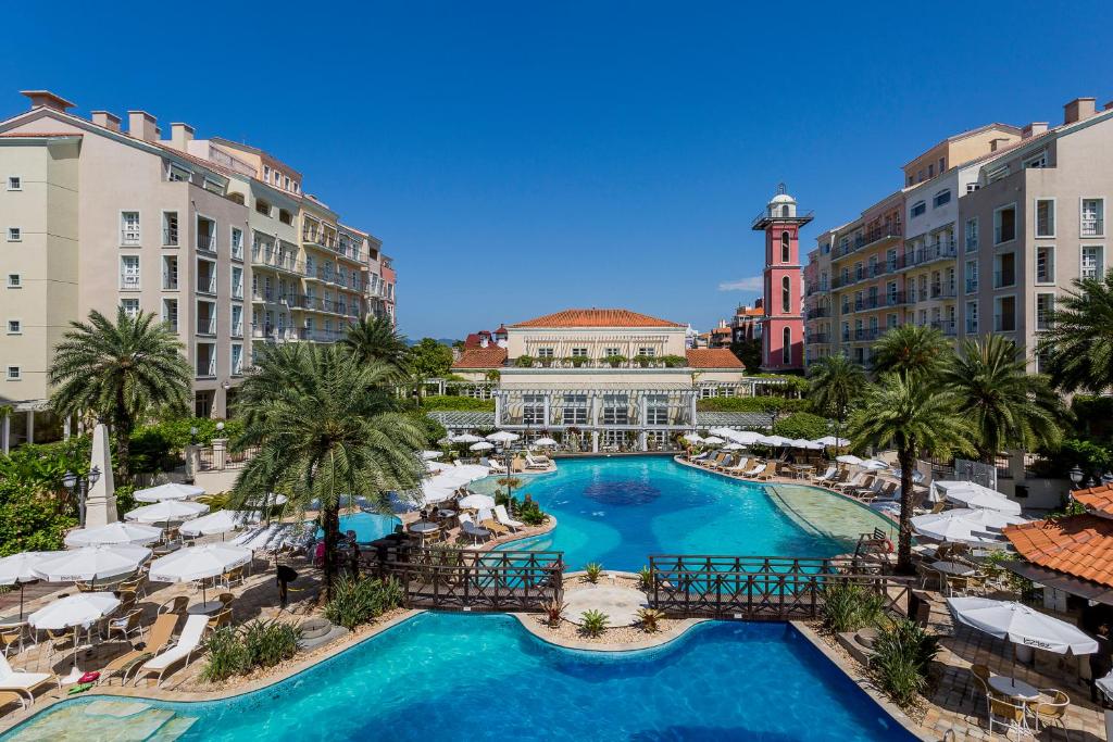 an overhead view of a pool with palm trees and buildings at IL Campanario Villaggio Resort in Florianópolis