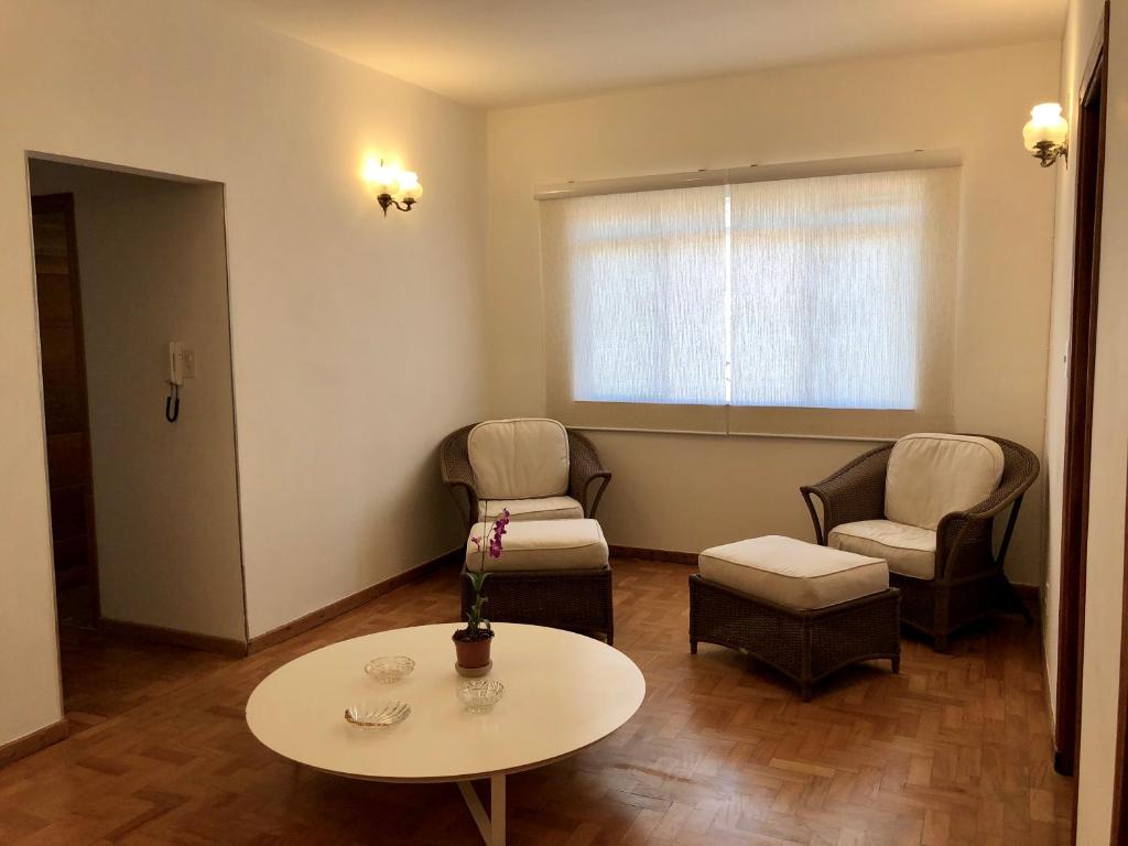 sala de estar con 2 sillas, mesa y ventana en Pousada Monte Alegre, en São Paulo