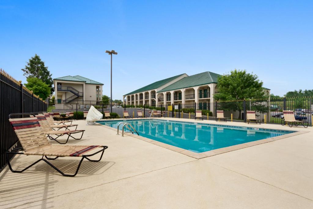 a swimming pool at a resort with chairs and a building at Baymont by Wyndham Johnson City in Johnson City