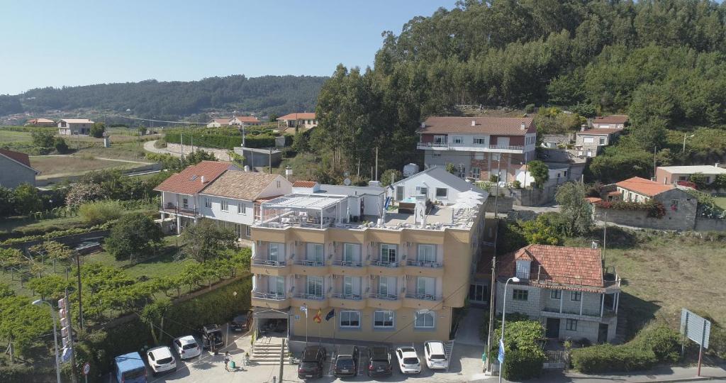 an aerial view of a town with a yellow building at Hotel Ancora SANXENXO in Granxa