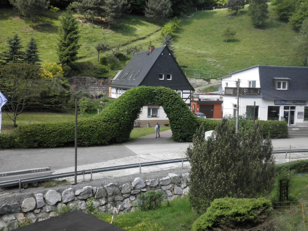 um arbusto em forma de arco em frente a uma casa em Ferienwohnung im Prossner Gründel em Bad Schandau