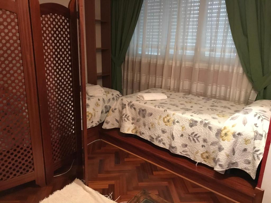 een slaapkamer met 2 bedden en een raam bij apartamento centrico cambados in Cambados