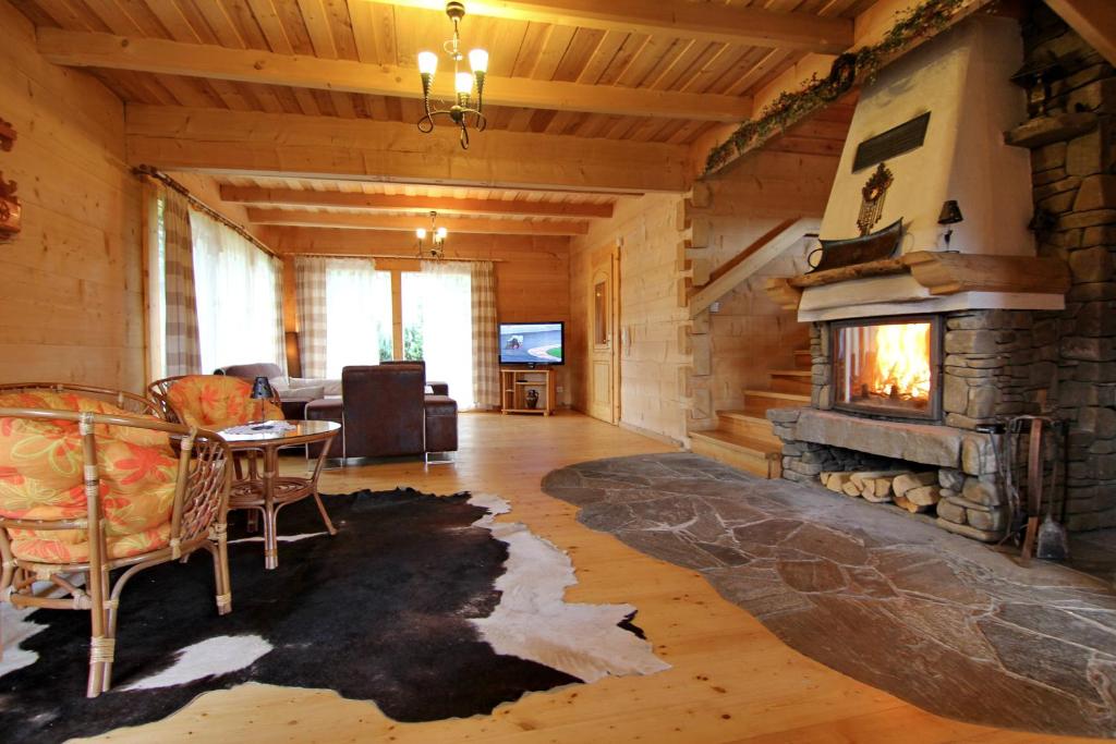 a living room with a fireplace in a log cabin at Domek Koziniec Zakopane in Zakopane