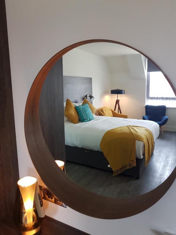 a bedroom with a bed with a large mirror at Base Dingle in Dingle