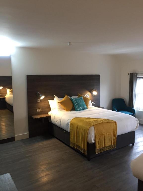 um quarto de hotel com uma cama grande com almofadas amarelas e azuis em Base Dingle em Dingle