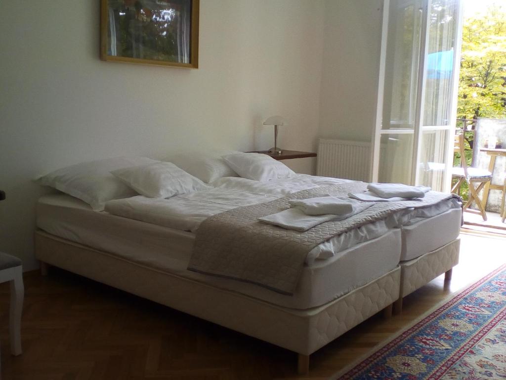 a bed sitting in a bedroom with a window at Deák apartmanok in Sopron