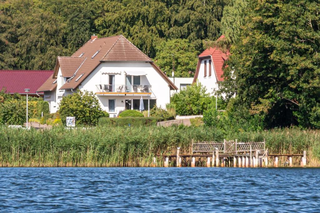 a house sitting on the shore of a lake at Strandhaus Malchow in Malchow