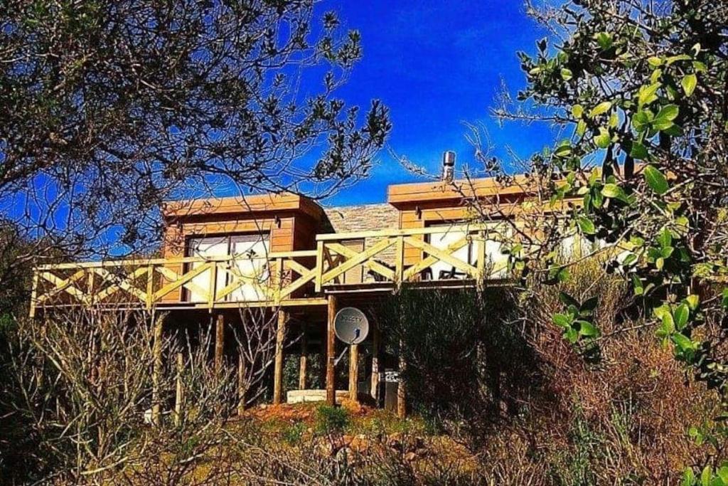 una casa en la cima de una colina con árboles en Villa Serrana Relax & Confort, en Villa Serrana