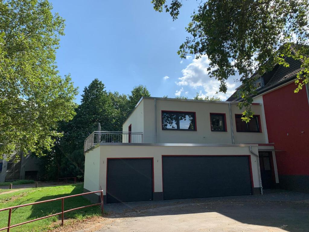 a house with two garage doors in front of it at Sonnige Apartments mit Terrasse in Essen