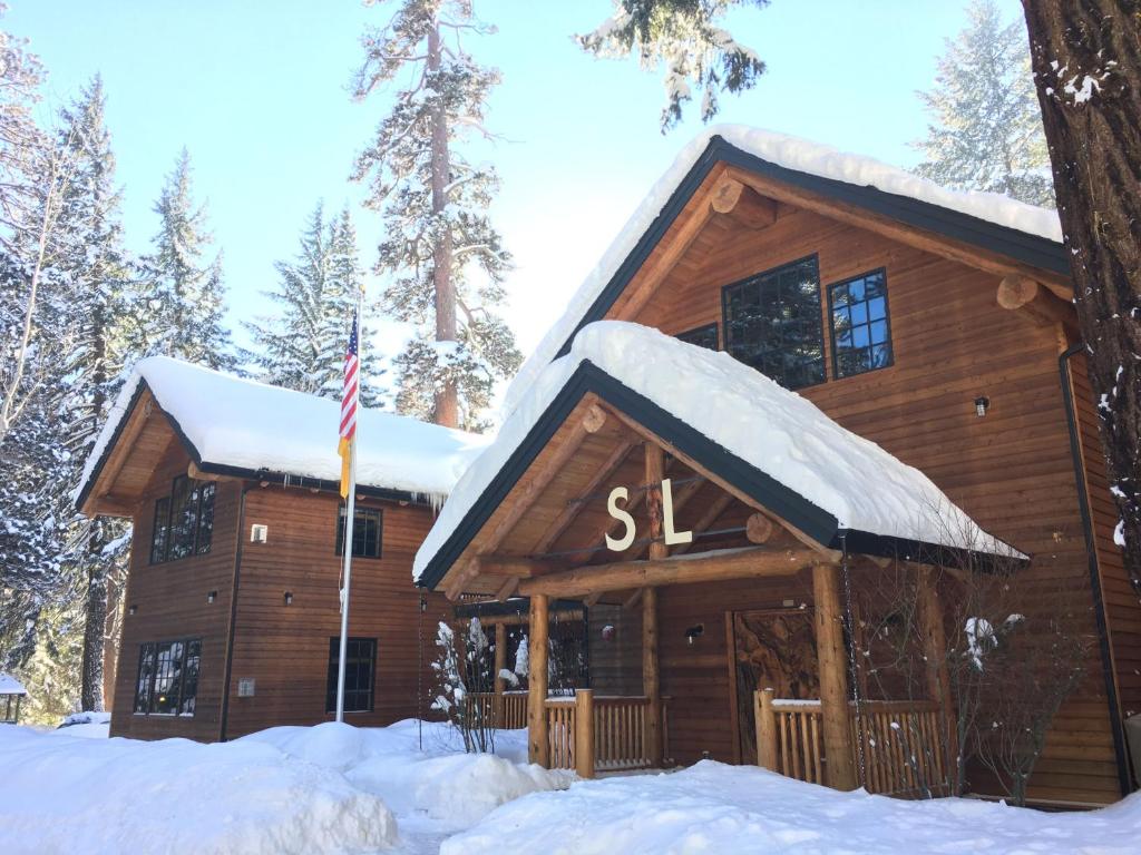 Camp ShermanにあるThe Suttle Lodge & Boathouseの旗を掲げた雪の丸太小屋