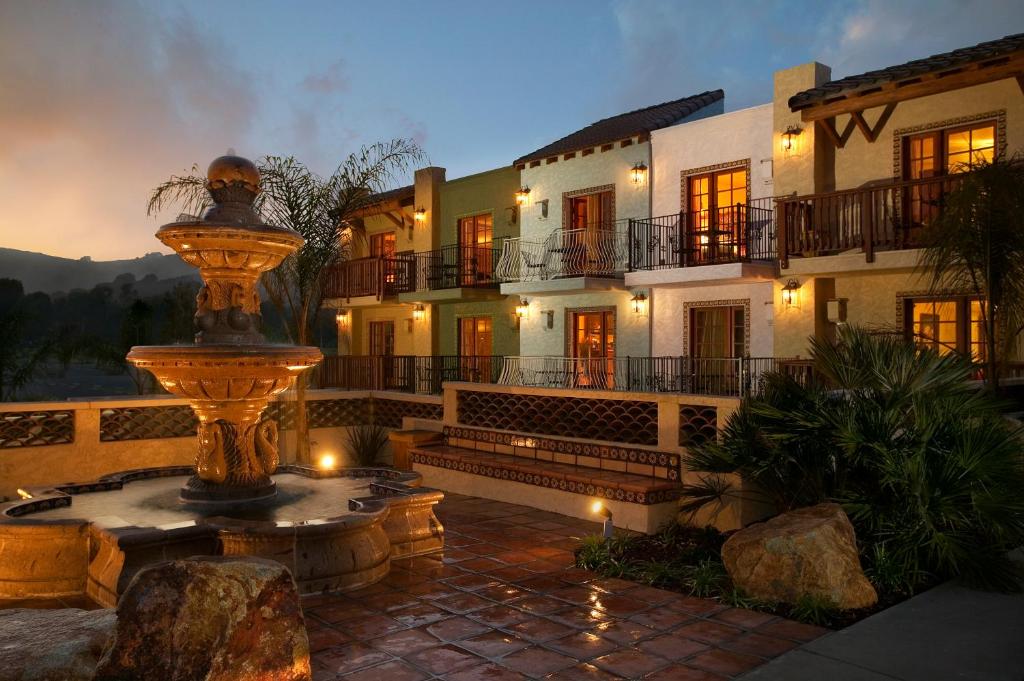 ein großes Gebäude mit einem Brunnen in der Mitte eines Innenhofs in der Unterkunft Avila La Fonda Hotel in Avila Beach