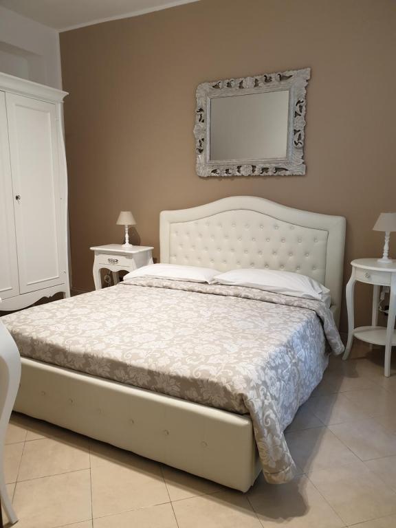 um quarto com uma cama e duas mesas e um espelho em Dimoramuri B&B em Catânia