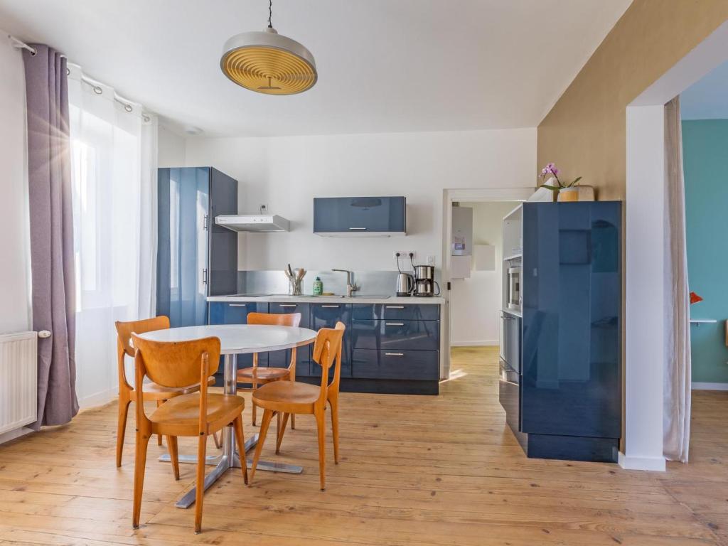 una cucina e una sala da pranzo con tavolo e sedie di Le Passage - appartement lumineux à La Madeleine ad Albi
