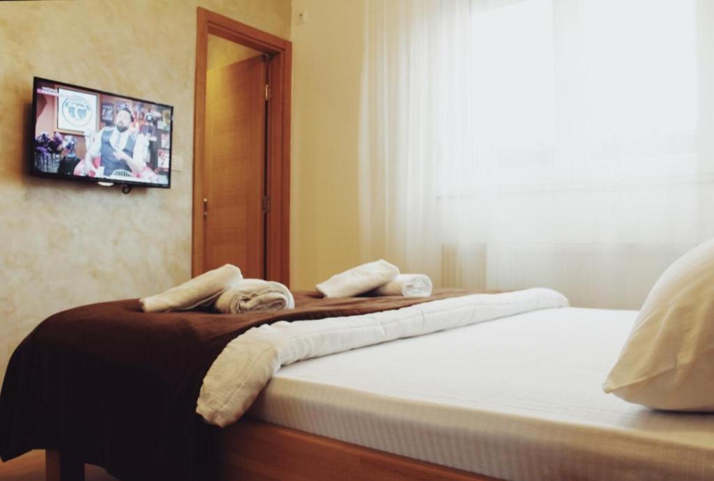 a bedroom with two beds and a tv on the wall at Konačište Simče in Kraljevo