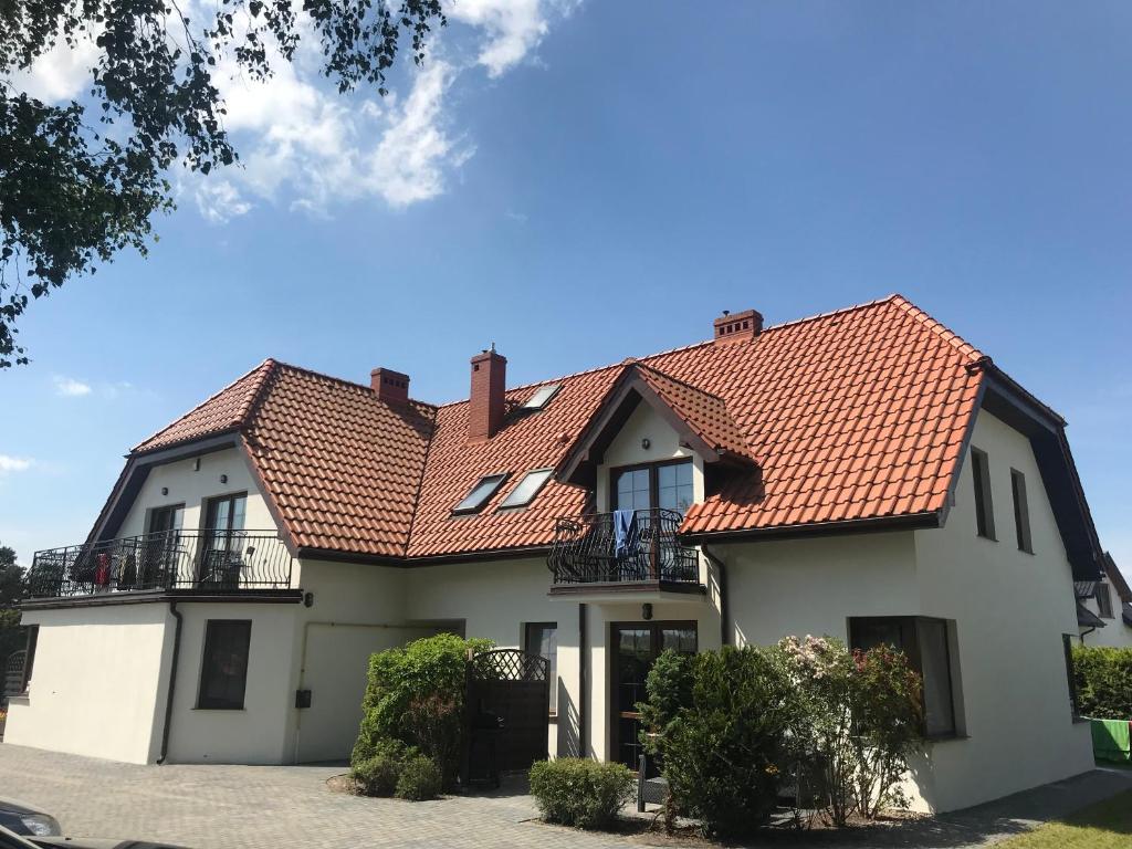 a white house with a red roof at Azyl in Dębki