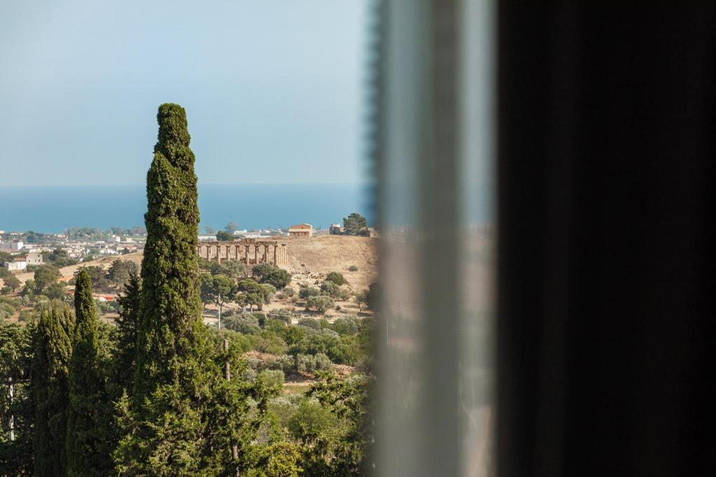 una vista de la acrópolis desde una ventana con un árbol en B&amp;B Dimora dei Templi, en Agrigento