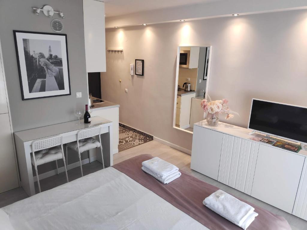 a large white room with a bed and a mirror at Penthouse “Sky 16” Studio Apartment in Zagreb