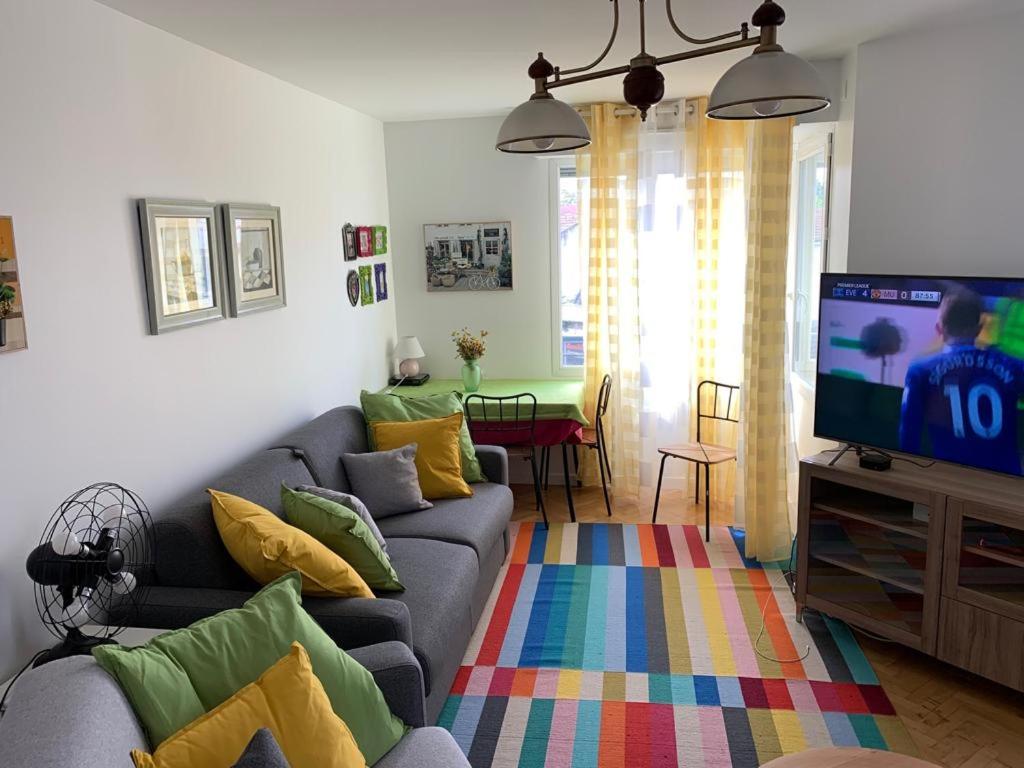 a living room with a couch and a tv at La Défense wonderful 2 bedrooms apartment in Suresnes