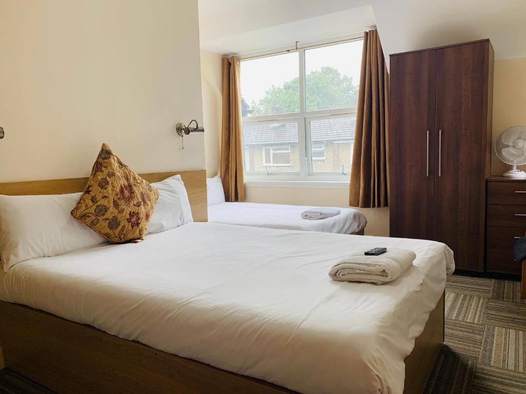 a bedroom with a large bed and a window at Albert Guest House in Kingston upon Thames