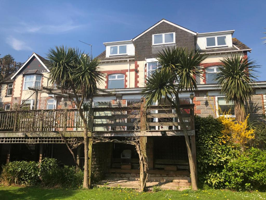 a house with two palm trees in front of it at Everglades Hotel in Torquay