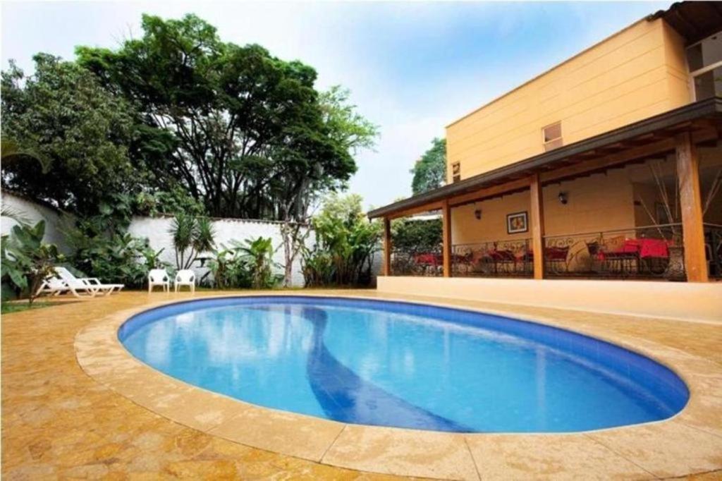 a swimming pool in front of a house at Hotel Portales Del Campestre in Medellín