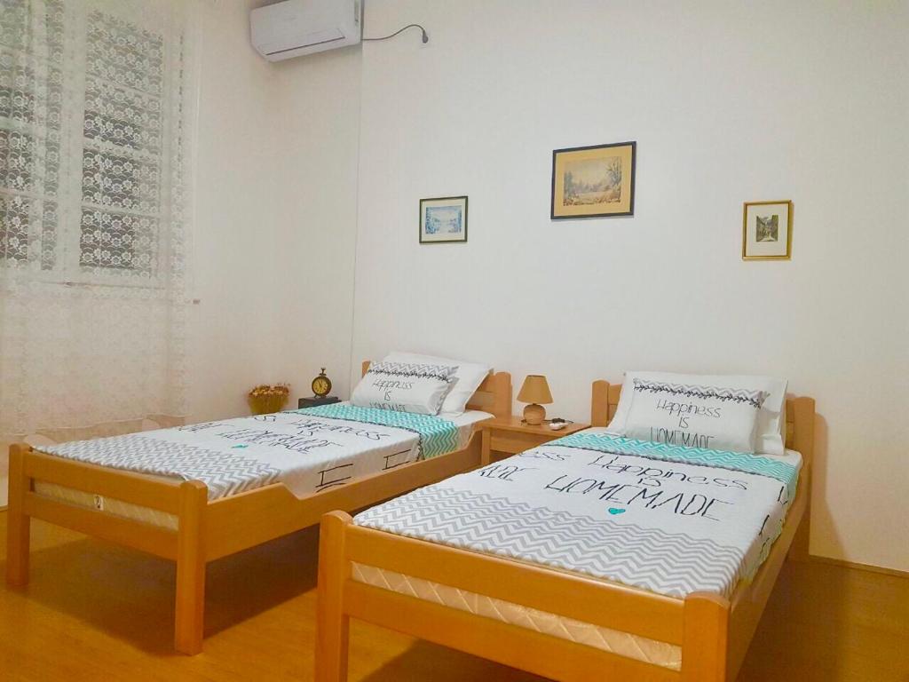 two twin beds in a room with at Podgorica Center in Podgorica