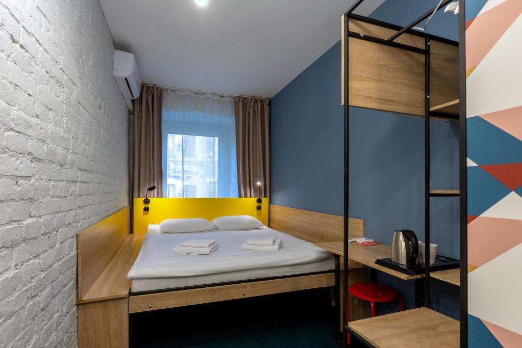 a bedroom with a bed with a yellow and blue wall at Axel Hotel Moscow in Moscow