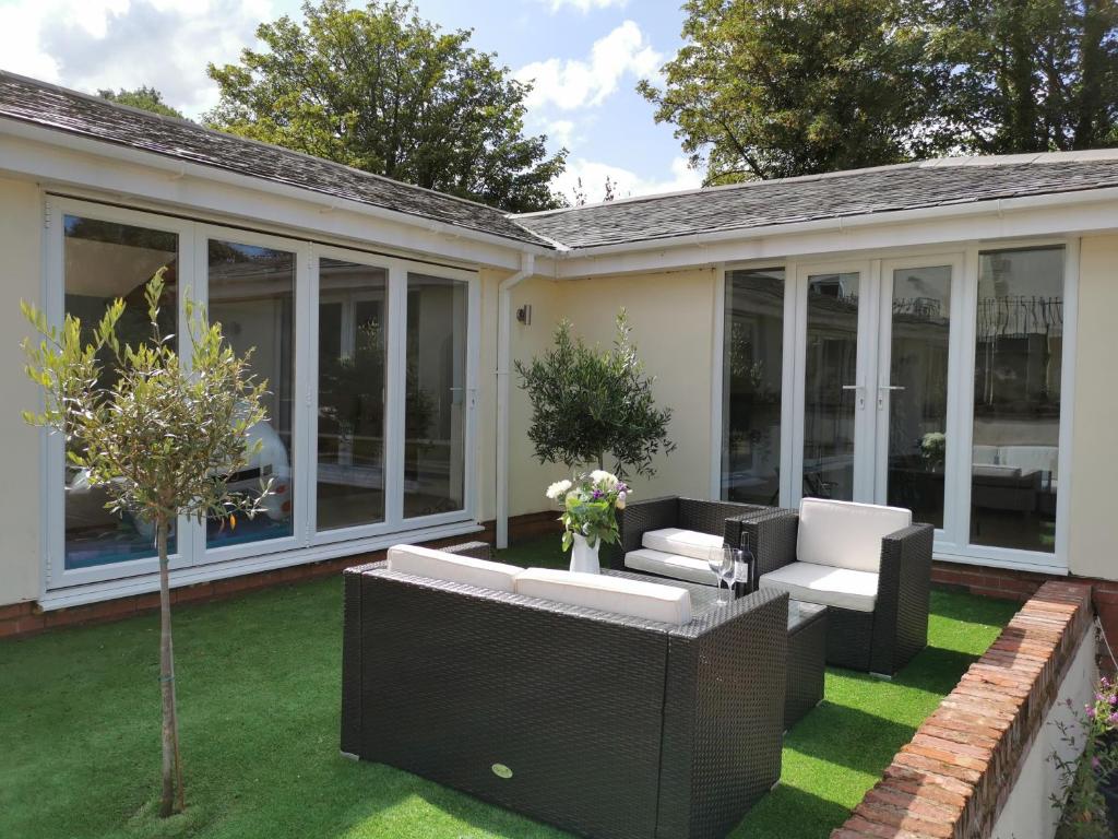a screened in patio with white furniture and a tree at Couples Country Escape includes Private Indoor Pool and Hot tub in North Wales in Bagillt