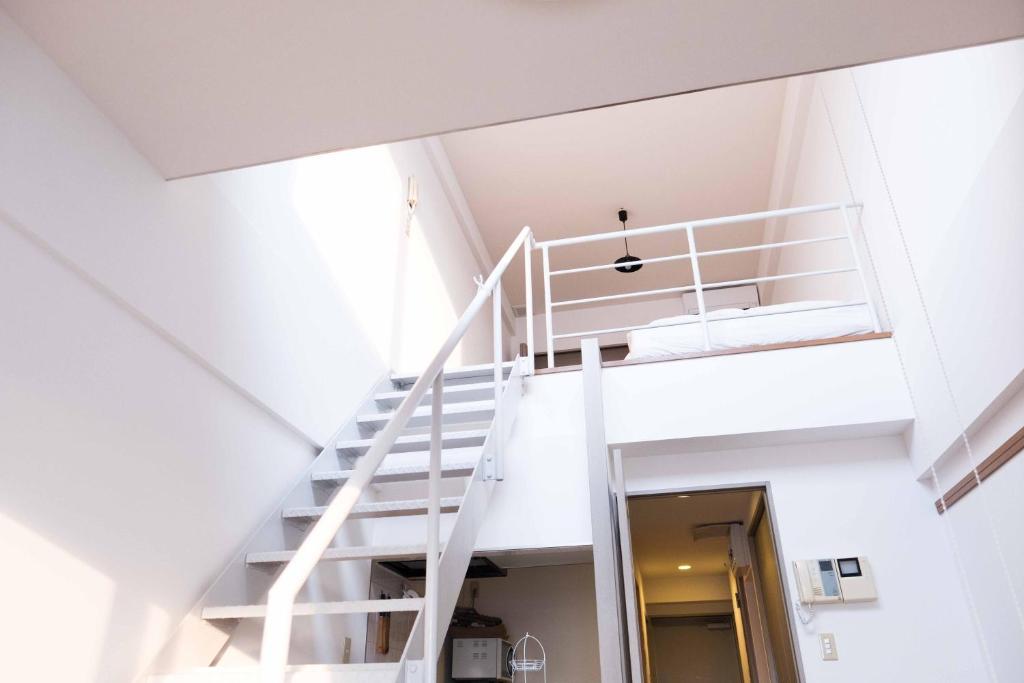 Una escalera de caracol blanca en una habitación blanca en MINIMAL SHIMOKITA Stylish Loft or Studio Apt, en Tokio