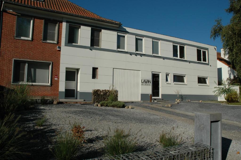 a white building with a brick building at Lavan in Leuven