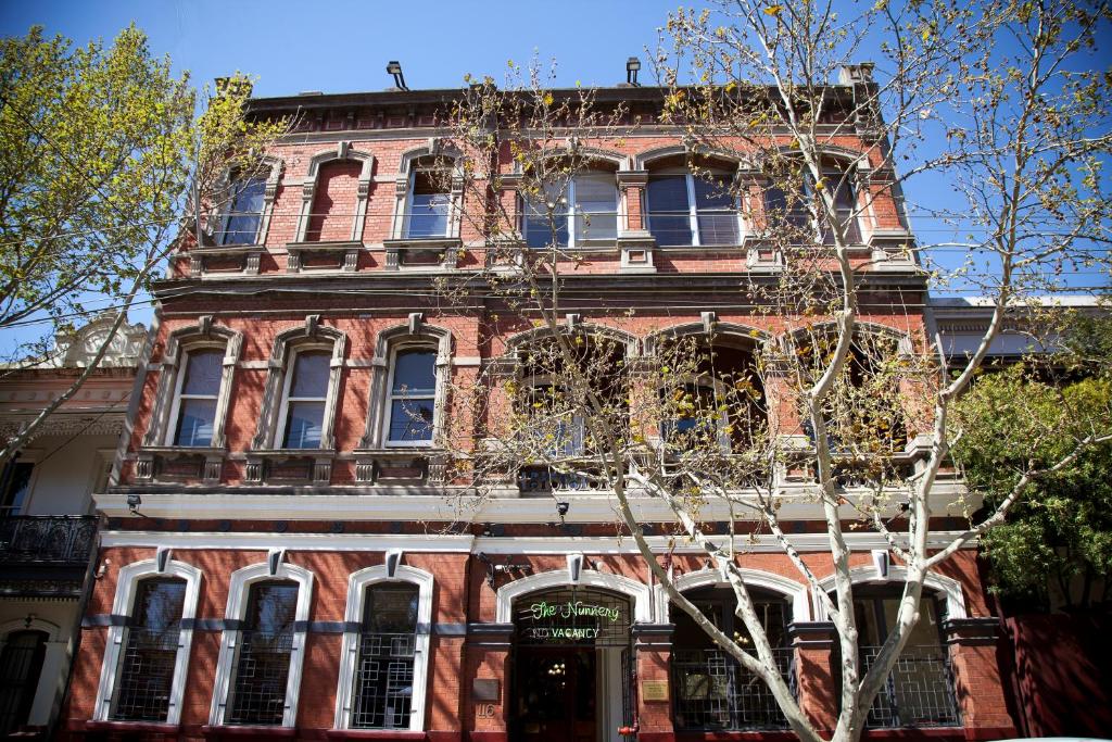 a red brick building with a tree in front of it at The Nunnery Accommodation in Melbourne