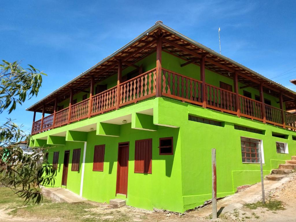 ein grünes Gebäude mit Balkon oben in der Unterkunft Sobrado Flor de Maio in Milho Verde