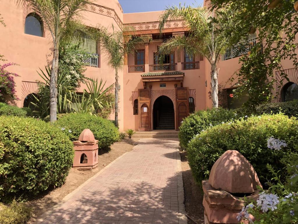 een huis met een loopbrug voor een gebouw bij Palmeraie Charly's in Marrakesh