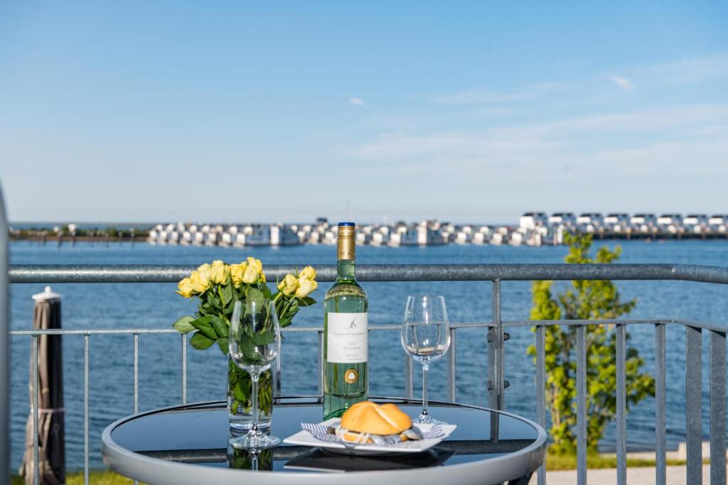 un tavolo con una bottiglia di vino e due bicchieri di Hafengeflüster a Olpenitz