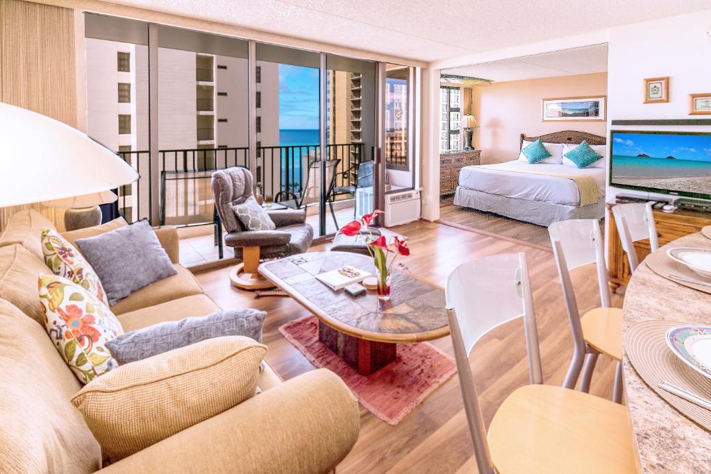 Tropical Escape, Ocean Views Condo with Parking في هونولولو: غرفة معيشة مع أريكة وطاولة