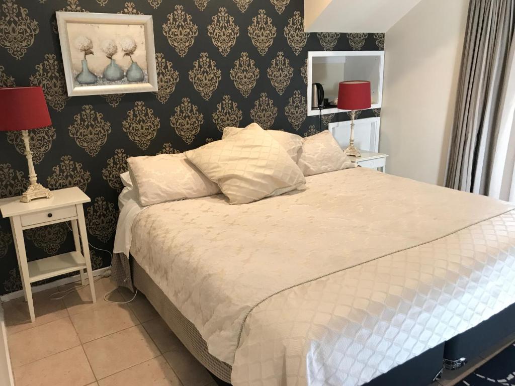 a bedroom with a bed and two lamps on tables at Linley House in Sydney