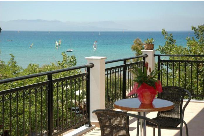 a table and chairs on a balcony with a view of the ocean at Maistrali in Vasiliki