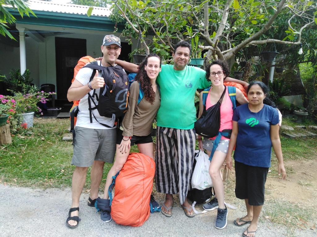 a group of people posing for a picture in front of a house at Asiri HomeStay in Sigiriya