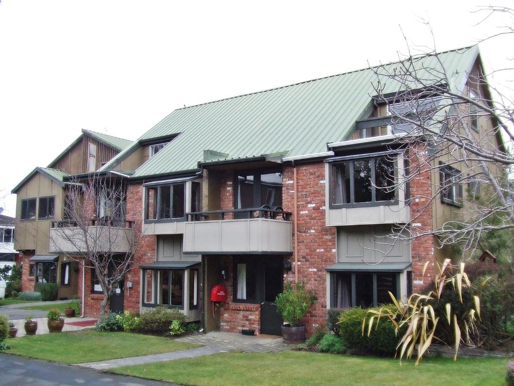 ein großes Backsteingebäude mit grünem Dach in der Unterkunft Woodlands Motels And Apartments in Dunedin