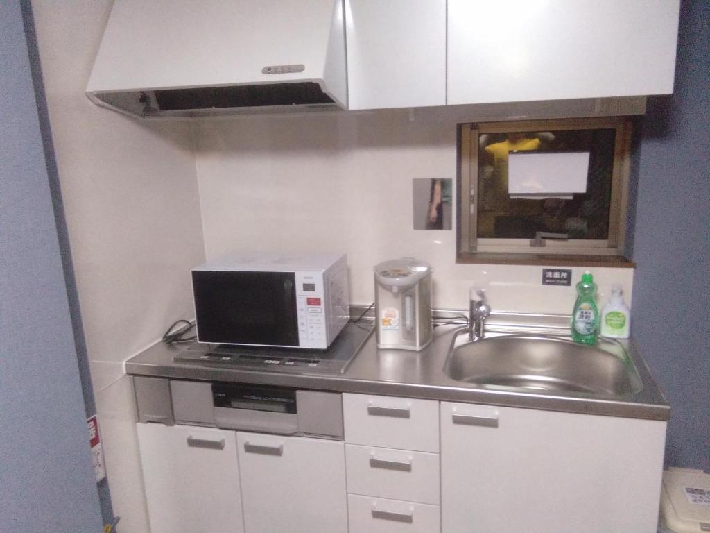 Kuchyň nebo kuchyňský kout v ubytování Nice Hostel Yahiro
