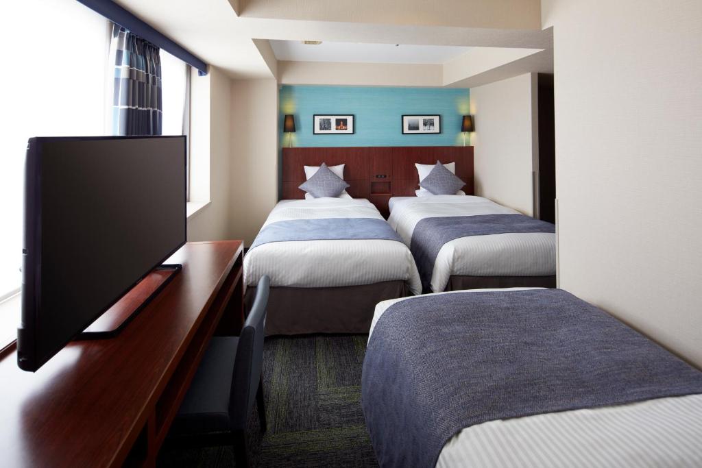 Postel nebo postele na pokoji v ubytování HOTEL MYSTAYS Yokohama